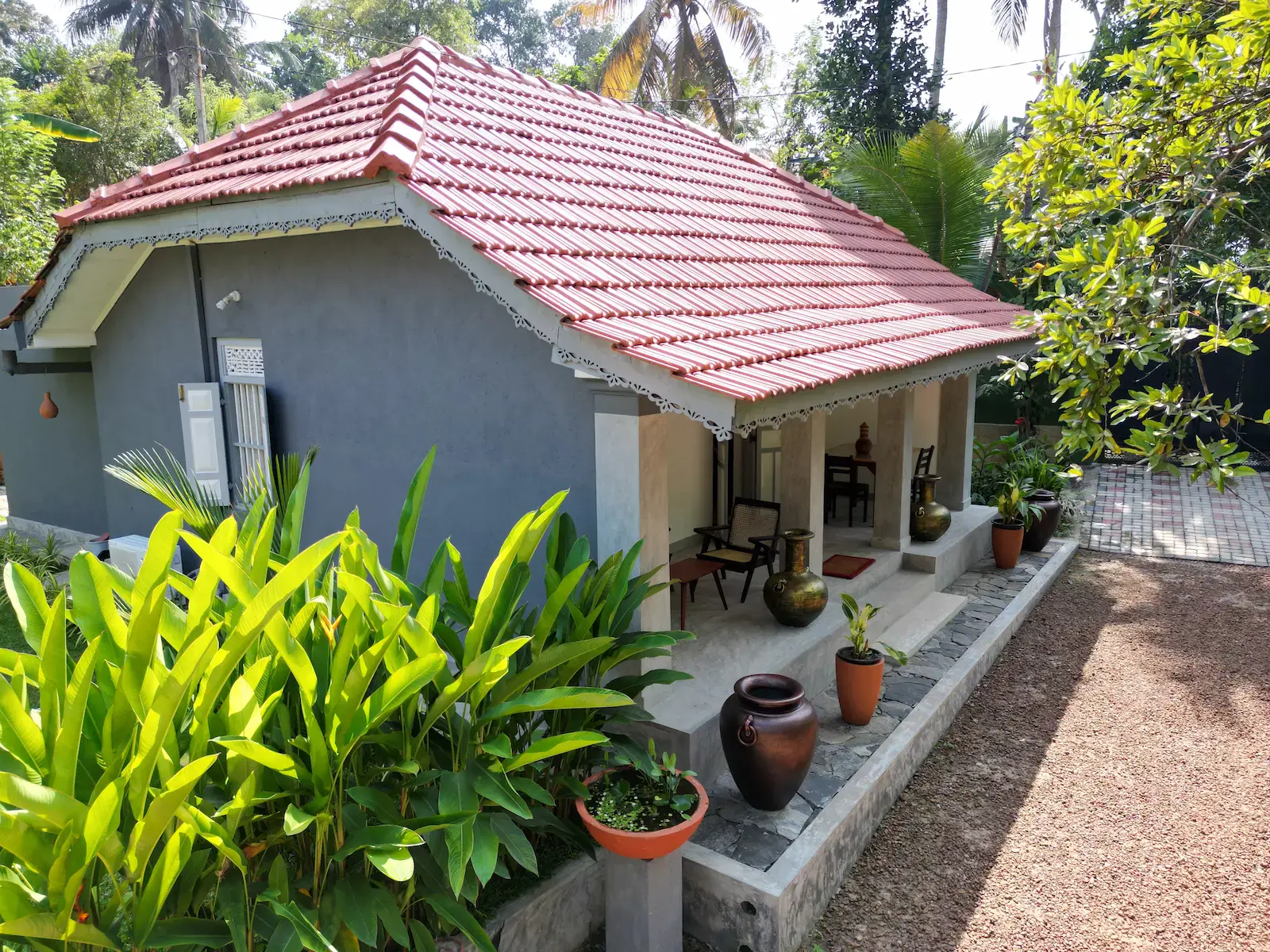 Birdsong Villa side terrace with traditional clay pots and wooden furniture