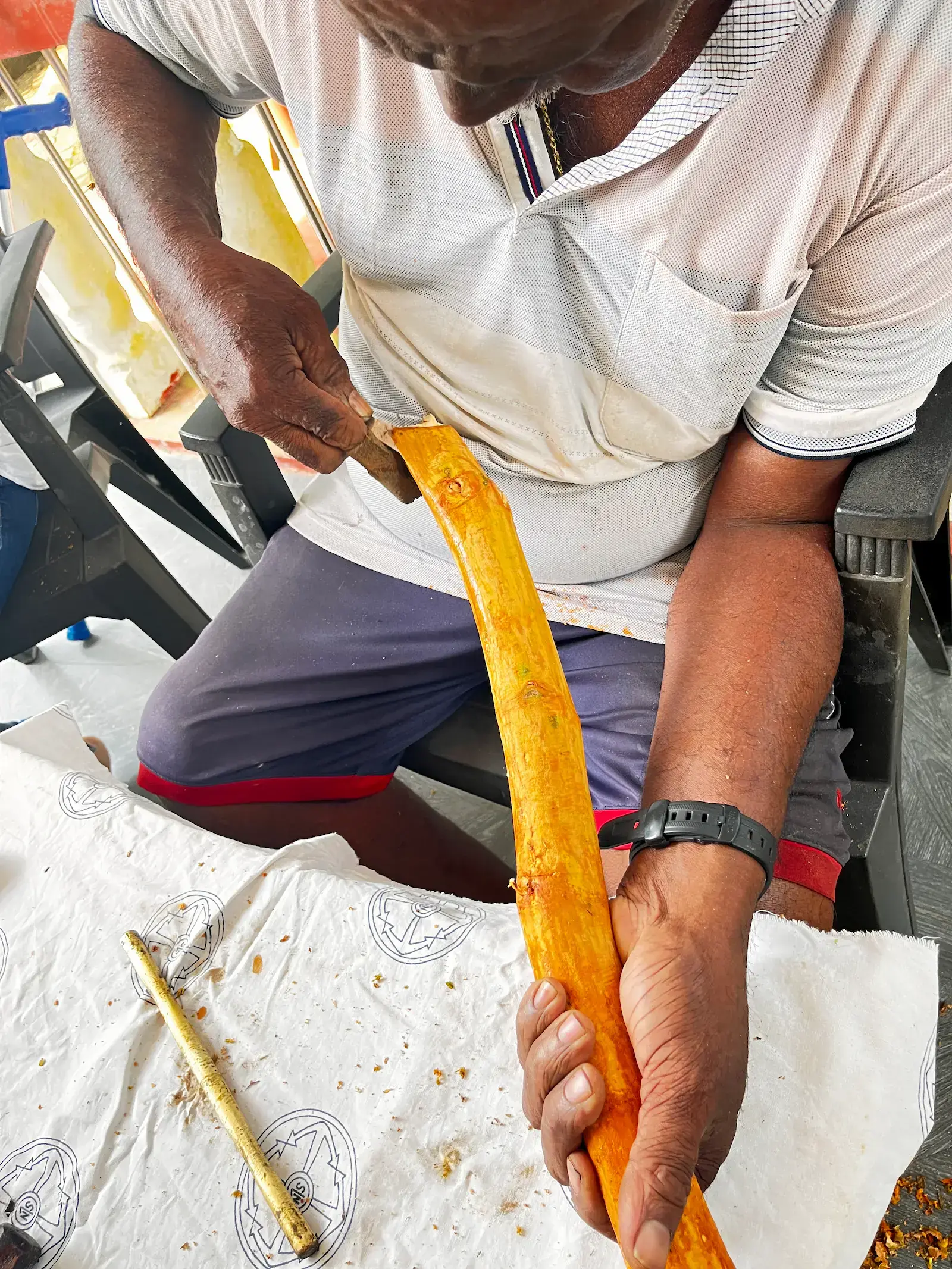 Nahaufnahme von Händen beim Polieren eines leuchtend gelblich-orangen Zimtstäbchens