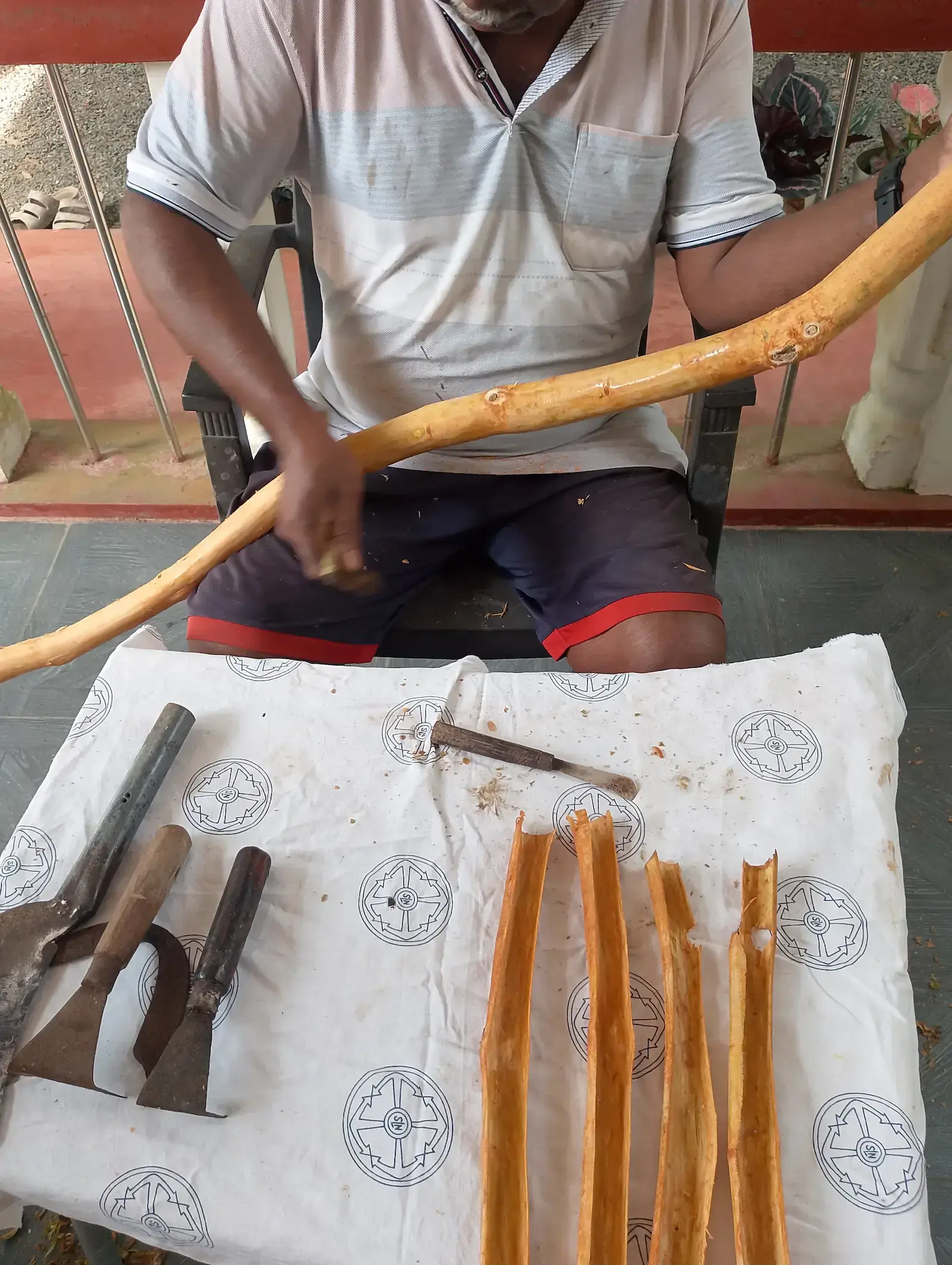 Traditional cinnamon processing tools and freshly peeled cinnamon sticks on a table