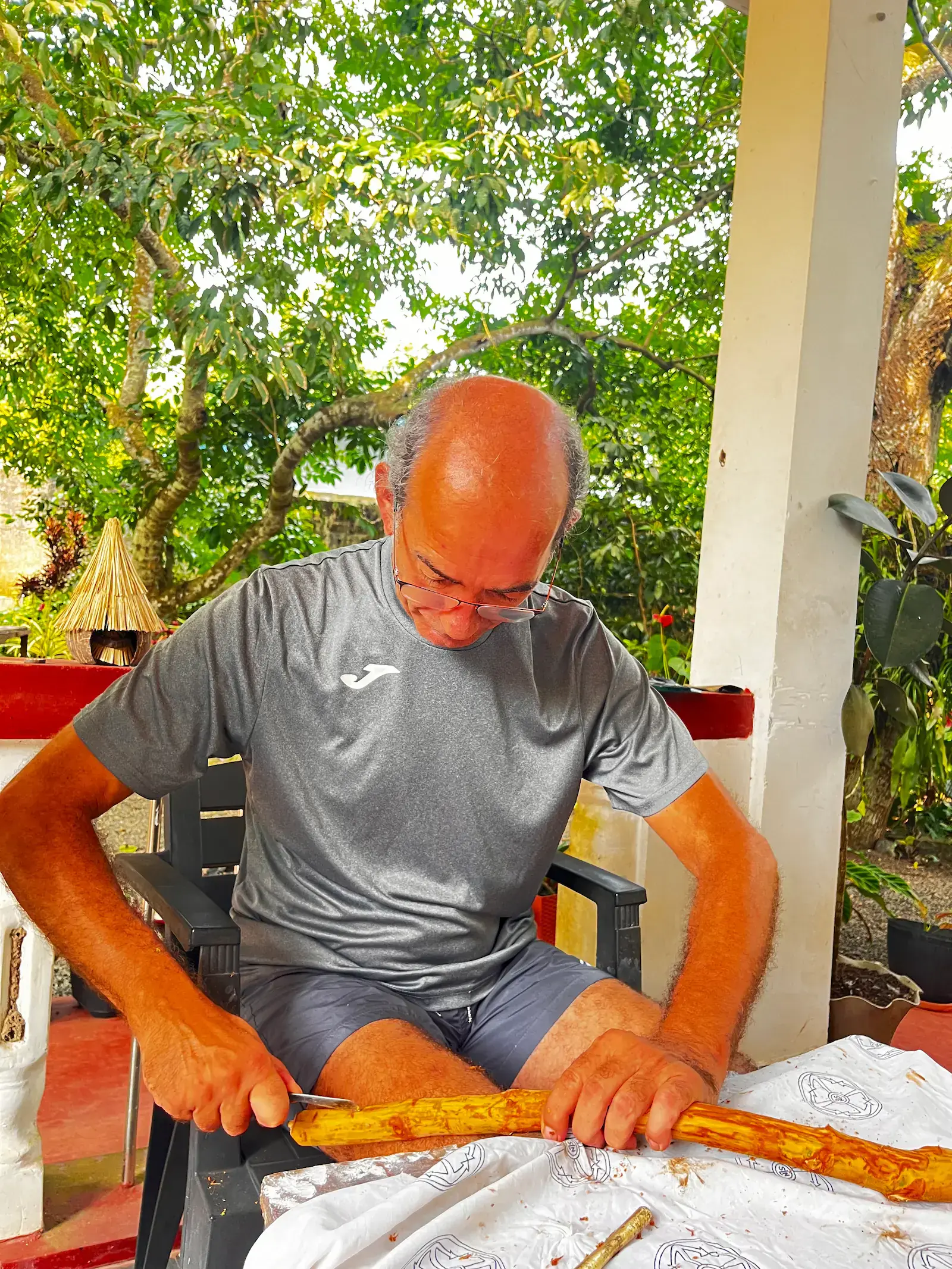 Gast verfeinert sorgfältig ein Zimtstäbchen mit einem kleinen Messer, Zimthandwerk-Detail