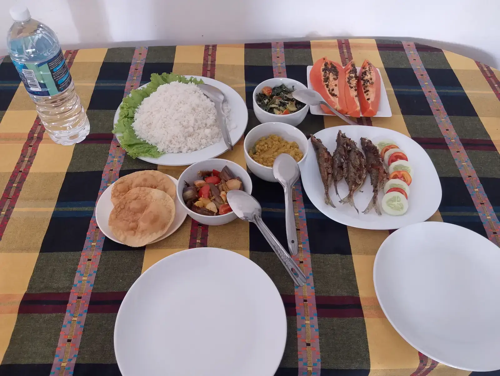 Traditional Sri Lankan lunch with rice, curries, fried fish and fresh papaya