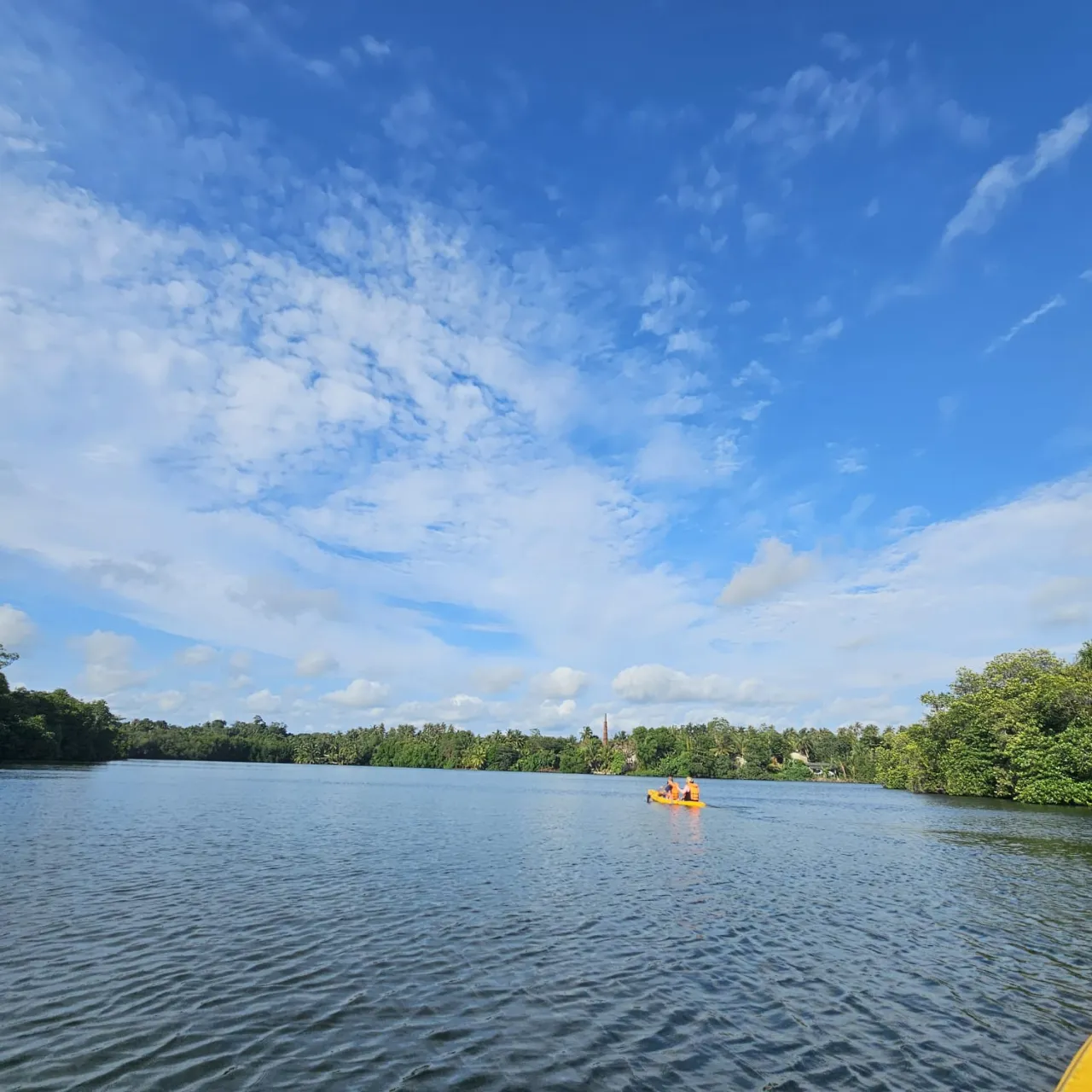 Panoramic view of Rathgama Lagoon with a distant kayak beneath a wide open sky