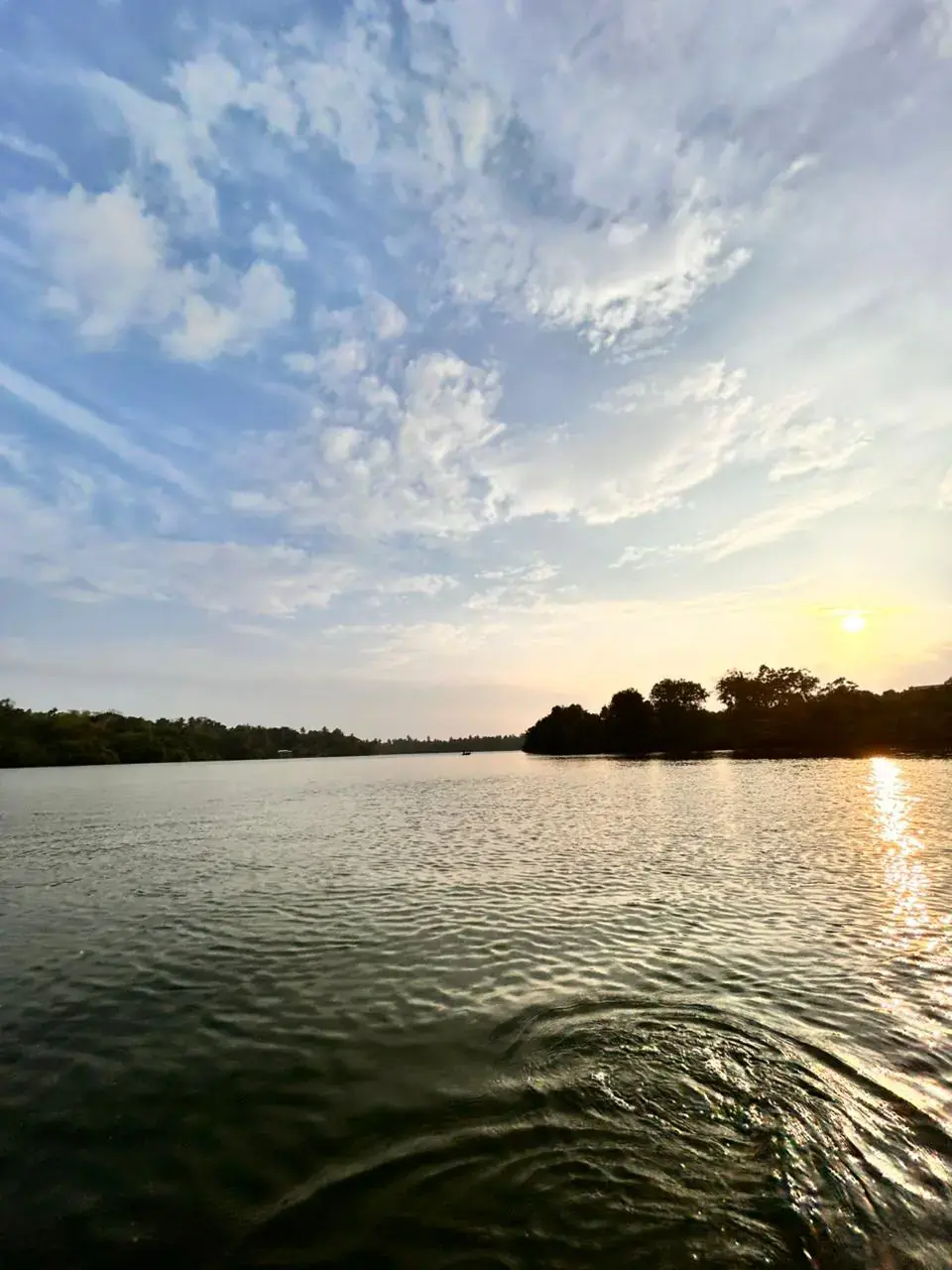 Serene sunrise reflections on the calm peaceful waters of Rathgama Lagoon, Southern Sri Lanka