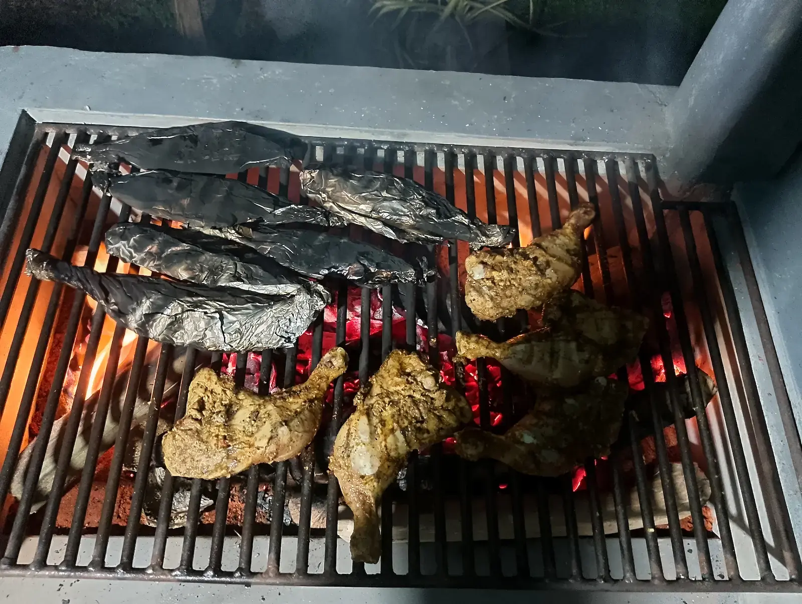 Abend-Barbecue mit Hähnchen auf Steingrill in einem privaten Garten, stilles Erlebnis