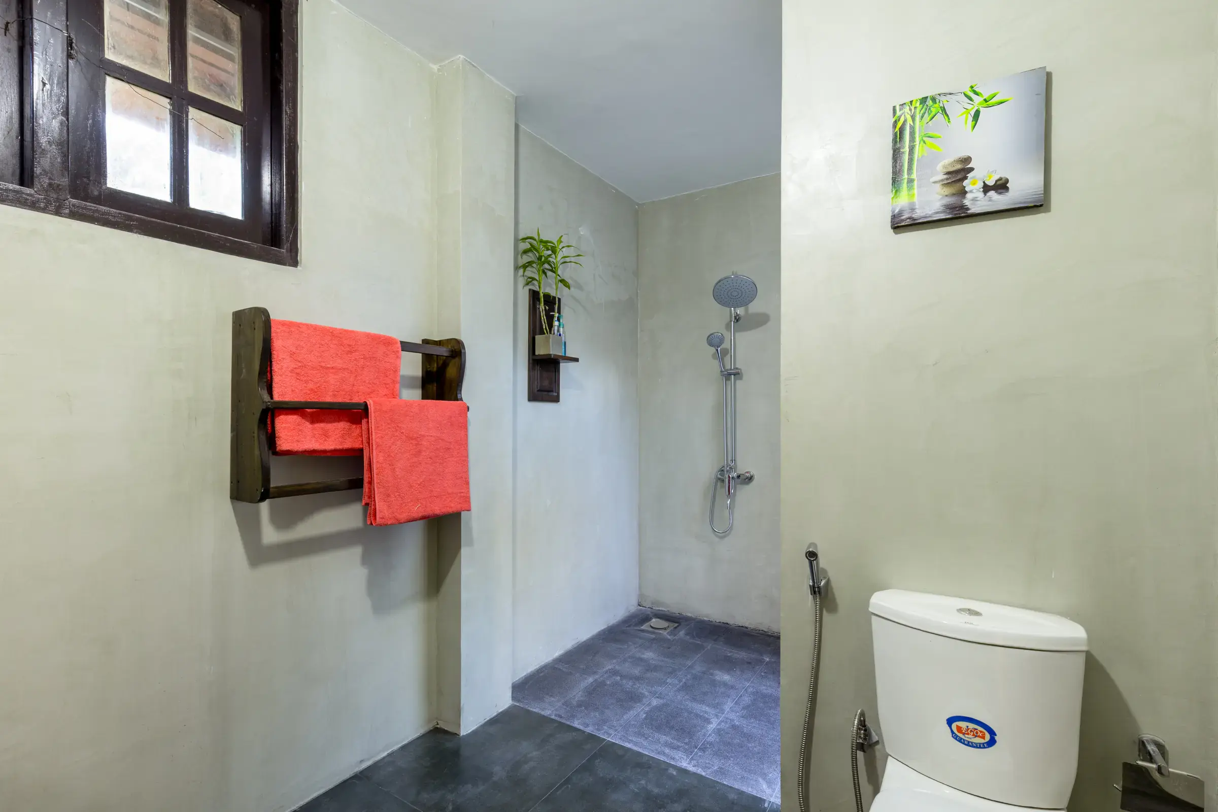 Private bathroom with wooden towel rack, orange towels and walk-in shower at Serene Luxe Villa